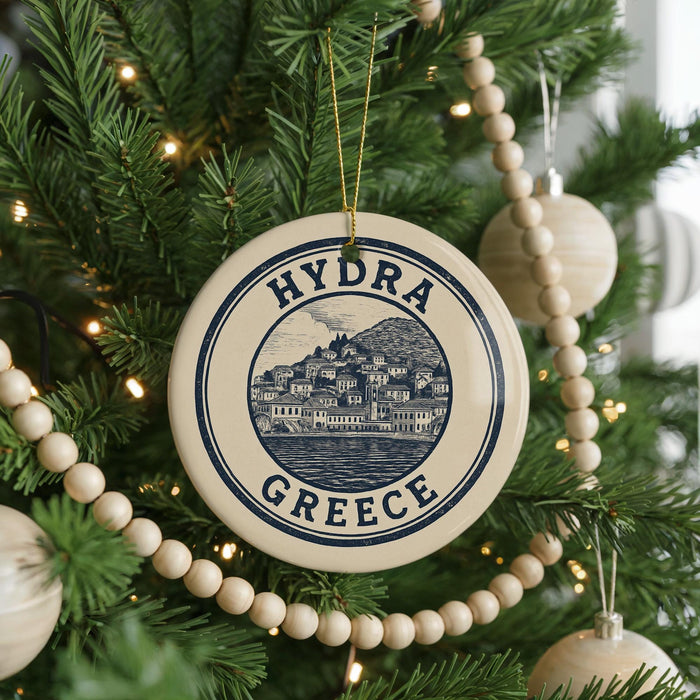 A round ornament on a Christmas tree, featuring a graphic of a Greek island and the text "HYDRA GREECE".