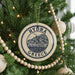 A round ornament on a Christmas tree, featuring a graphic of a Greek island and the text "HYDRA GREECE".
