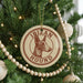 A Christmas tree decorated with ornaments, including a circular ornament with the text "IBIZAN HOUND" and a wooden bead decoration.
