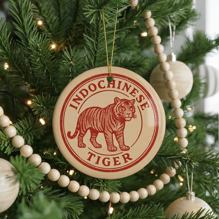 A Christmas tree decorated with ornaments, including a circular ornament with a tiger image and the text "INDOCOCHINESE TIGER".