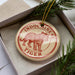 A decorative ornament in a box, featuring a tiger illustration and the text "INDOCINESE TIGER".