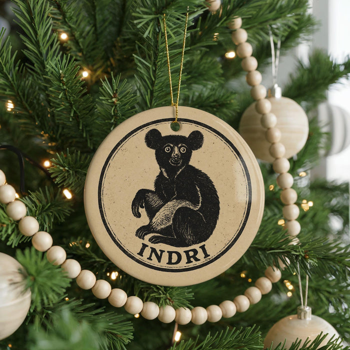 A Christmas tree decorated with ornaments, including a circular ornament featuring a bear and the word "INDRI".