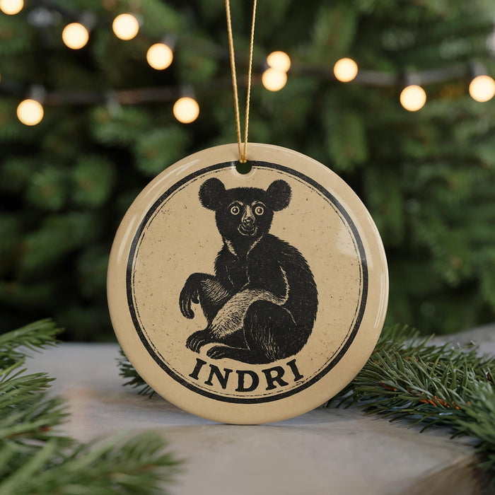 A round ornament featuring a black bear sitting on its hind legs, with the word "INDRI" written below the image.