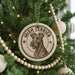 A circular ornament on a Christmas tree featuring an illustration of an Irish Terrier dog.