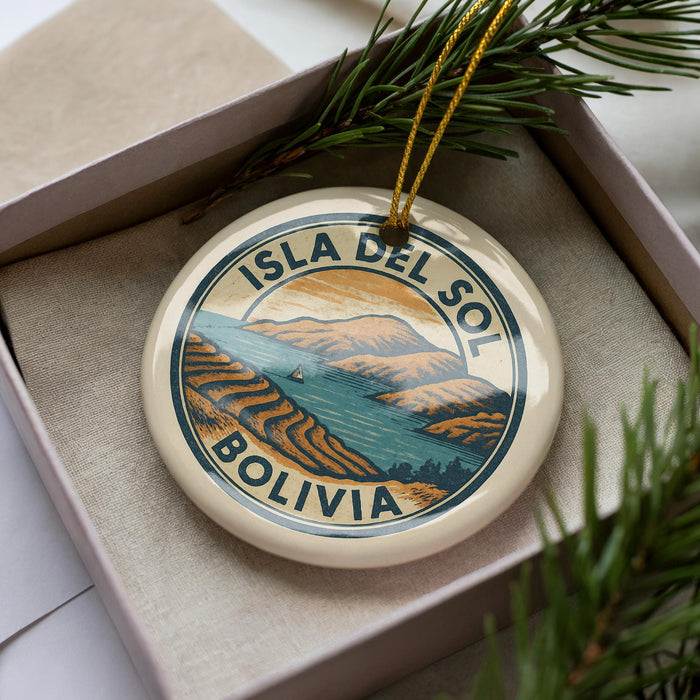 A circular ornament with the text "ISLA DEL SOL BOLIVIA" printed on it, surrounded by a pine branch and pine needles.