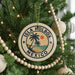 A circular ornament on a Christmas tree, featuring a palm tree and the text "ISLA HOLBOX MEXICO" in a circular design.