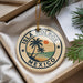A circular ornament with the text "ISLA HOLBOX MEXICO" and a palm tree design, hanging from a string.