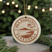 A circular ornament with the text "ISLA MARGARITA VENEZUELA" printed on it, surrounded by a palm tree and a sunset.