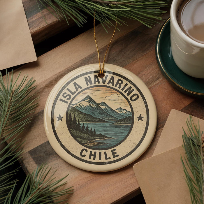 A circular ornament with the text "ISLA NAVARINO CHILE" printed on it, surrounded by pine branches and a cup of coffee on a wooden surface.