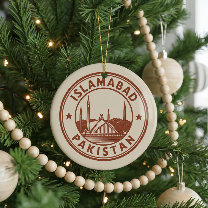 A circular ornament on a Christmas tree, featuring the text "ISLAMABAD PAKISTAN" and an illustration of the Mughal Mosque in Lahore, Pakistan.