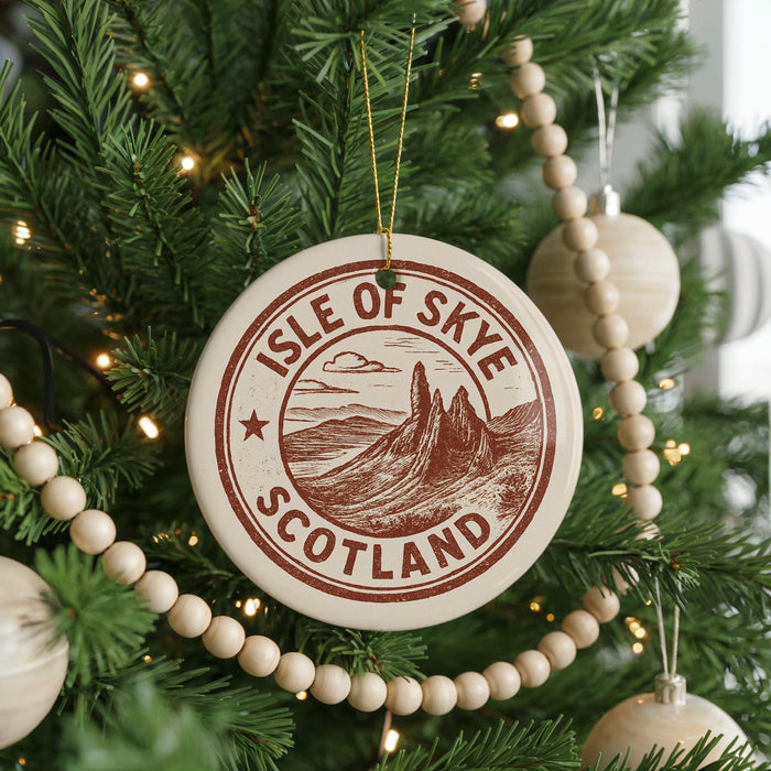 A Christmas tree decorated with ornaments, including a circular ornament with the text "ISLE OF SKYE SCOTLAND" and a mountain landscape.