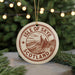 A circular ornament with the text "ISLE OF SKYE SCOTLAND" printed on it, surrounded by pine branches and twinkling lights.