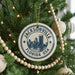 A Christmas tree decorated with ornaments, including a circular ornament with the text "JACKSONVILLE FLORIDA USA" and a cityscape design.