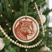 A Christmas tree decorated with ornaments, including a red and white ornament featuring a leopard's face.