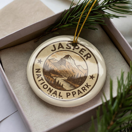 A circular ornament with the text "JASPER NATIONAL PARK CANADA" printed on it, surrounded by pine branches.