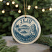 A decorative ornament featuring the text "Jeju South Korea" and an illustration of a stone statue, surrounded by a tropical landscape with palm trees and mountains.