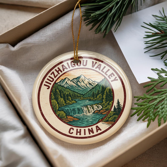 A decorative ornament with a mountain landscape and a waterfall, featuring the text "JUZHAI GONG VALLEY CHINA" on it.