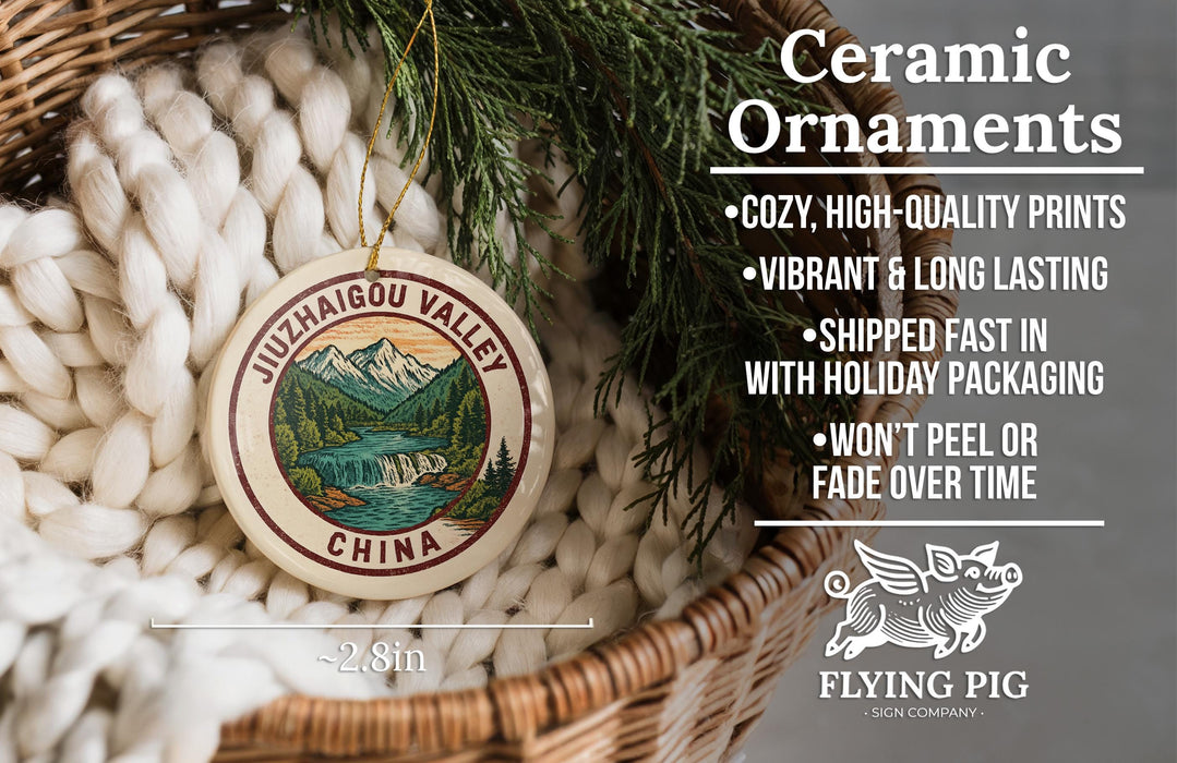 Ceramic ornaments, featuring a round ornament with a mountain landscape and a river, hanging from a wicker basket.