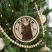 A Christmas tree decorated with ornaments, including a circular ornament with a picture of a dog and the name "Kai Ken" written on it.