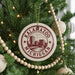 A Christmas tree decorated with ornaments, including a circular ornament with the text "KALAMAZOO, MICHIGAN" printed on it.