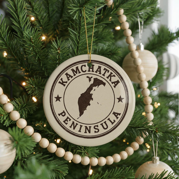 A Christmas tree decorated with ornaments, including a circular ornament with the text "KAMCHATKA PENINSULA" printed on it.