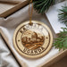 A circular ornament with the text "KAMPALA UGANDA" and an illustration of a cityscape, hanging from a string.