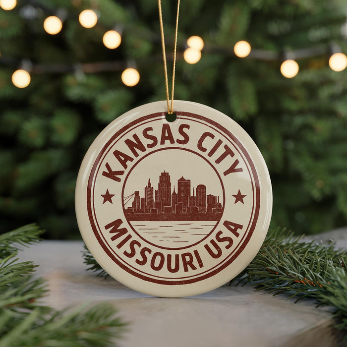 A circular ornament with the text "KANSAS CITY MISSOURI USA" printed on it, featuring a silhouette of a city skyline.