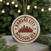 A circular ornament with the text "KANSAS CITY MISSOURI USA" printed on it, featuring a silhouette of a city skyline.