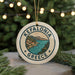 A circular ornament with the text "Kefalonia Greece" and an illustration of a coastal town, surrounded by Christmas lights and greenery.