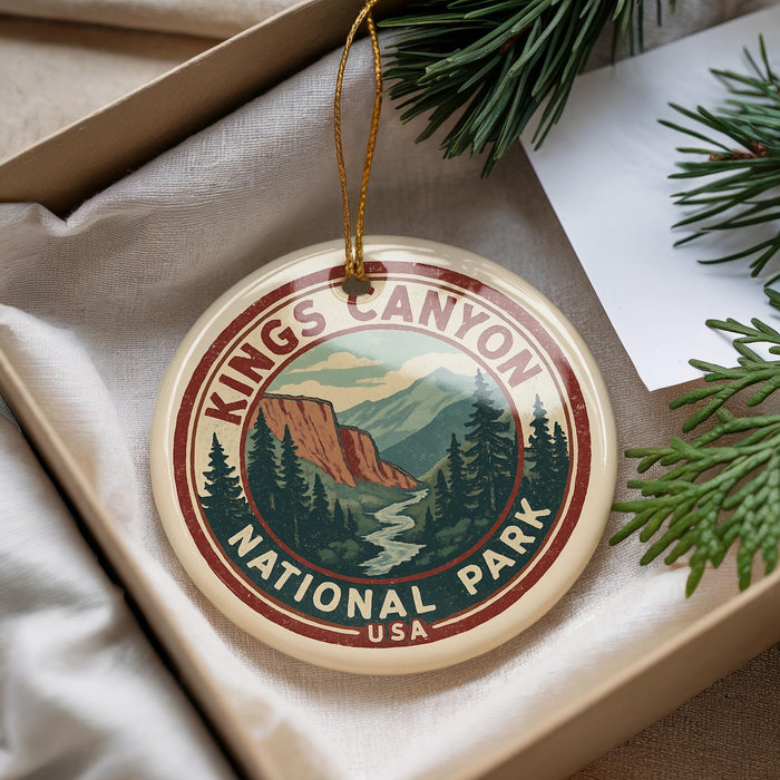 A decorative ornament with the text "Kings Canyon National Park" and a mountain landscape design, hanging from a string.
