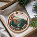 A decorative ornament with the text "Kings Canyon National Park" and a mountain landscape design, hanging from a string.