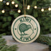 A circular ornament featuring a kiwi bird design, with the text "KIWI" prominently displayed.
