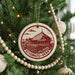 A Christmas tree decorated with ornaments, including a circular ornament with a red and white design depicting the Kiyomizu-Dera temple in Kyoto, Japan.