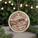 A circular ornament with the text "KOBUK VALLEY NATIONAL PARK USA" printed on it, hanging from a string.
