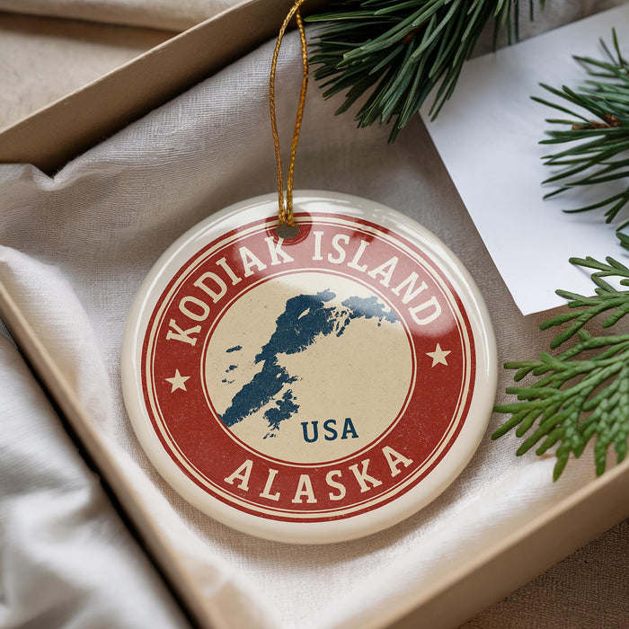 A circular ornament with the text "KODIAK ISLAND USA" printed on it, surrounded by pine branches and a white paper.