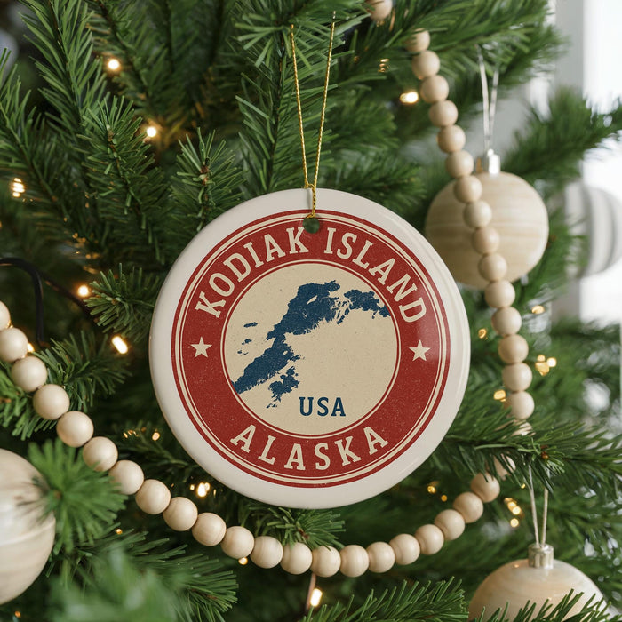 A Christmas tree decorated with ornaments, including a circular ornament with the text "KODIAK ISLAND USA" and a map of Alaska.