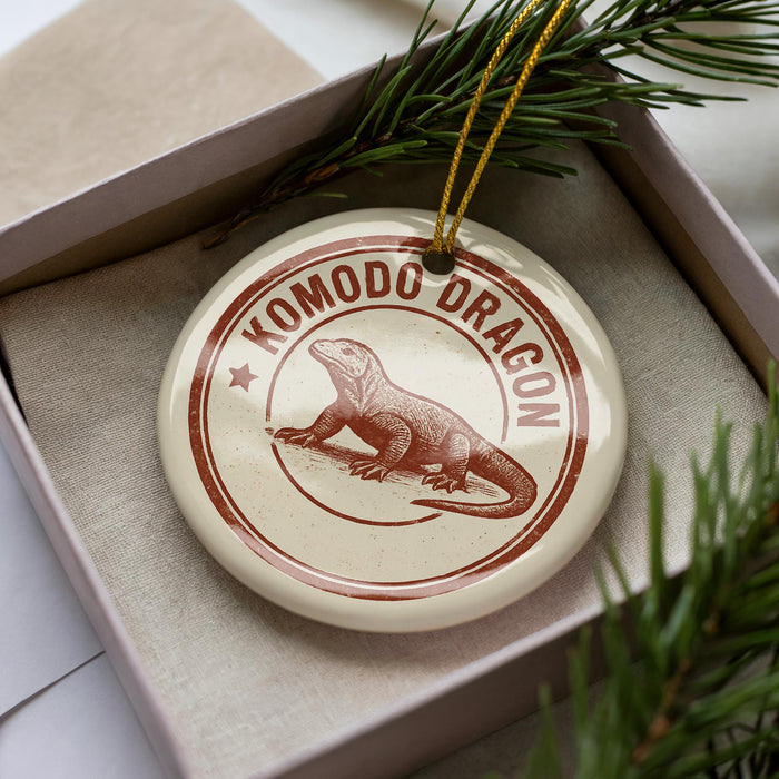 A decorative ornament in a box, featuring a komodo dragon illustration.