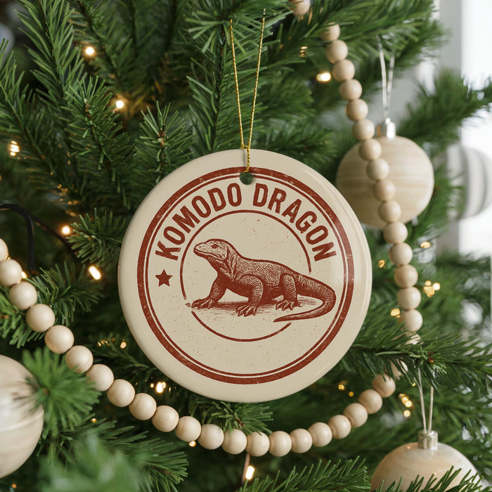 A Christmas tree decorated with ornaments, including a circular ornament with a red and white design featuring a komodo dragon.