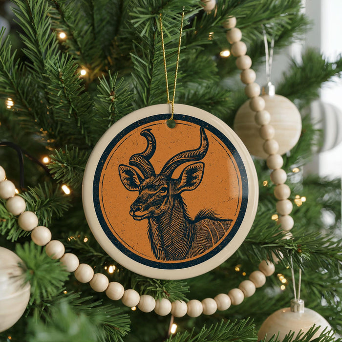 A Christmas tree decorated with ornaments, including a circular ornament featuring a stylized deer or antelope.