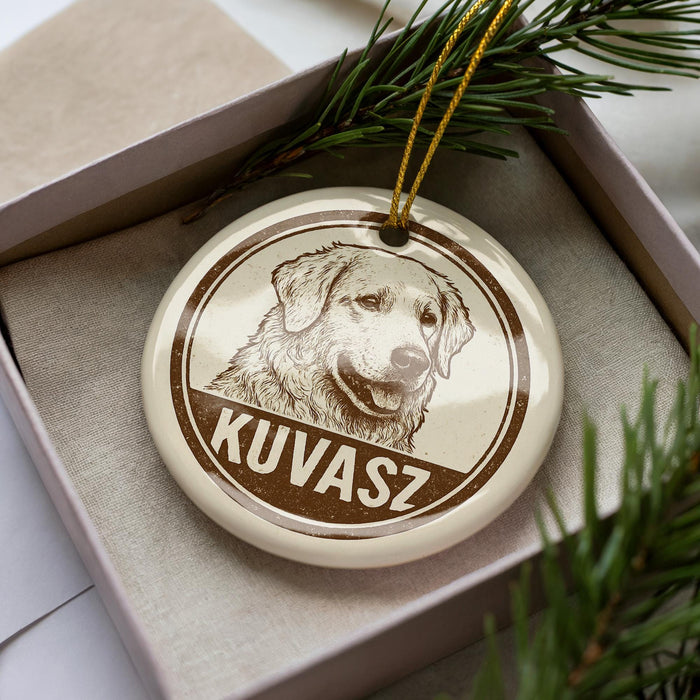 A circular ornament with a dog's face on it, placed inside a box with pine branches.