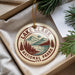 A circular ornament with the text "LAKE CLARK NATIONAL PARK USA" printed on it, hanging from a string.