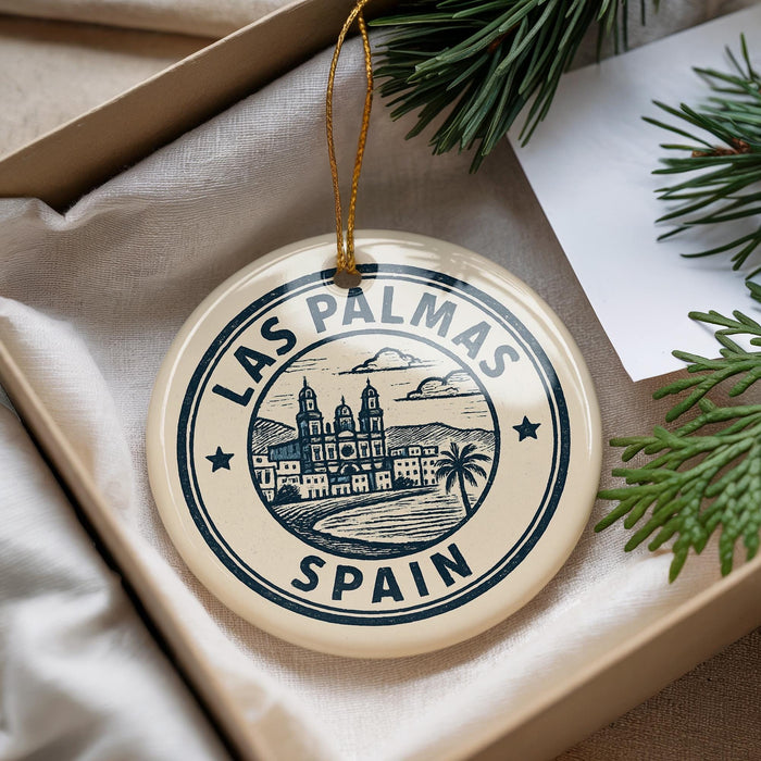 A circular ornament with the text "LAS PALMAS" and "SPAIN" printed on it, surrounded by a decorative border.
