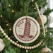 A Christmas tree decorated with ornaments, including a circular ornament with a picture of the Leaning Tower of Pisa and the text "PISA ITALY".