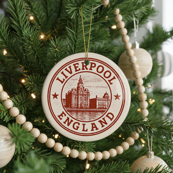 A Christmas tree decorated with ornaments, including a circular ornament with the text "LIVERPOOL ENGLAND" and a castle illustration.