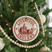 A Christmas tree decorated with ornaments, including a circular ornament with the text "LIVERPOOL ENGLAND" and a castle illustration.