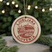 A circular ornament with the text "LJUBLJANA SLOVENIA" printed on it, hanging from a string.