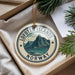 A circular ornament with the text "Lofoten Islands NORWAY" and a mountain landscape design, hanging from a string.