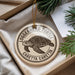 A circular ornament with a turtle design, hanging from a string.