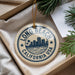 A circular ornament with the text "LONG BEACH CALIFORNIA USA" printed on it, hanging from a string.