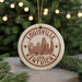 A circular ornament with the text "LOUISVILLE KENTUCKY USA" printed on it, featuring an illustration of a city skyline.